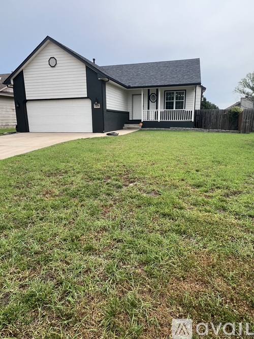 A two-story house with a garage and a fenced yard.