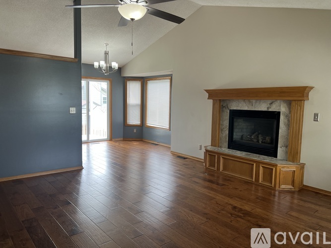A living room with a fireplace and wood flooring.
