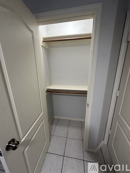 A small, empty room with a door and a window.