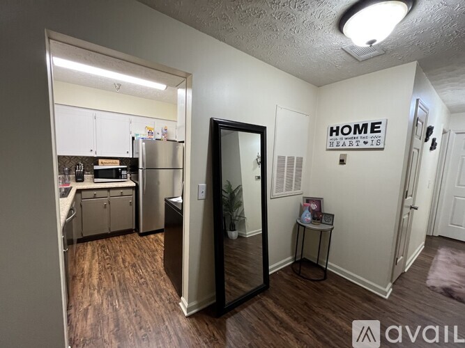 A small kitchen with white cabinets and a fridge.