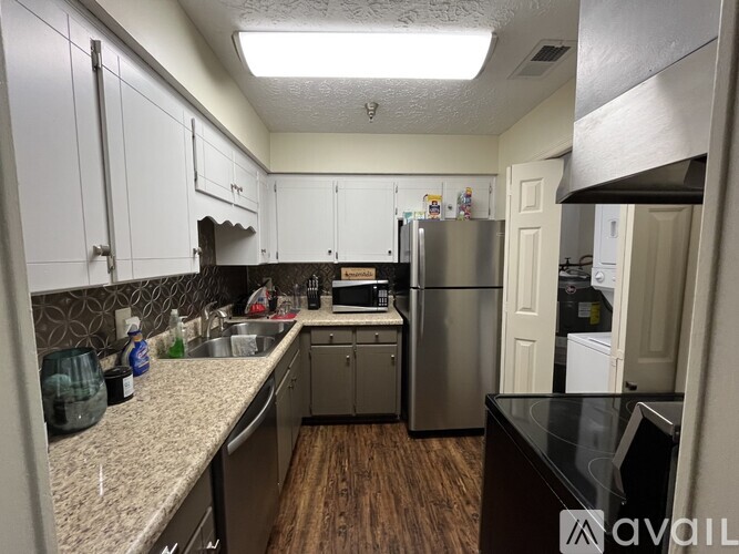A kitchen with a refrigerator, sink, and cabinets.