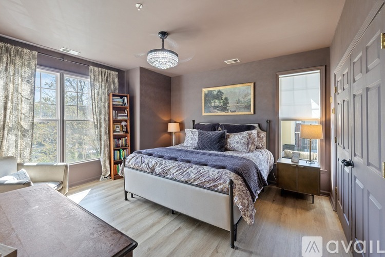 A bedroom with a large bed and a painting on the wall.