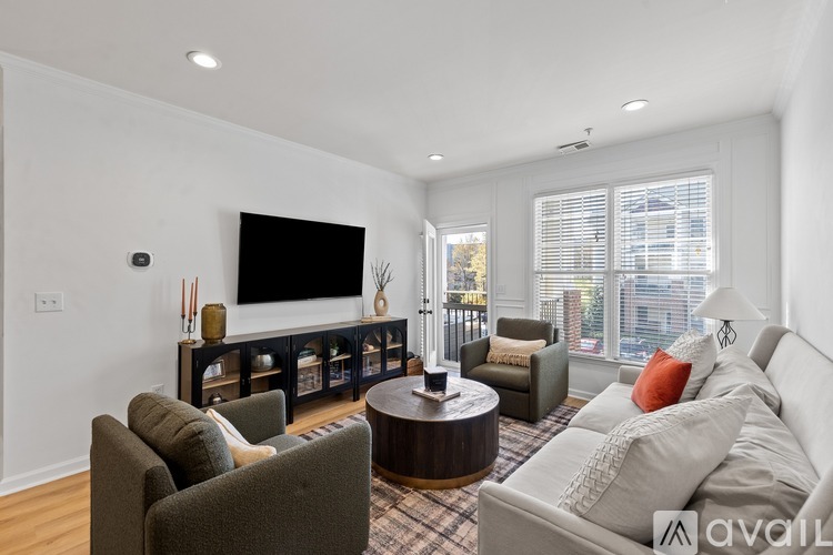 A living room with a grey couch, a brown coffee table, and a television on a stand.
