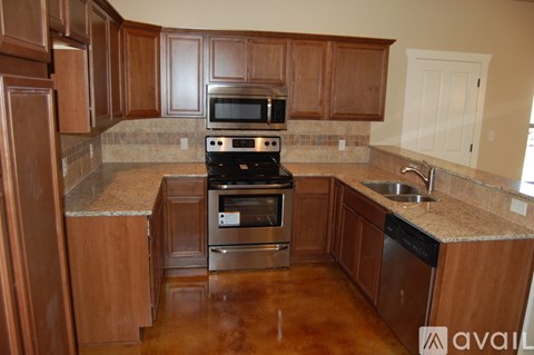 A kitchen with wooden cabinets and a stove top oven.