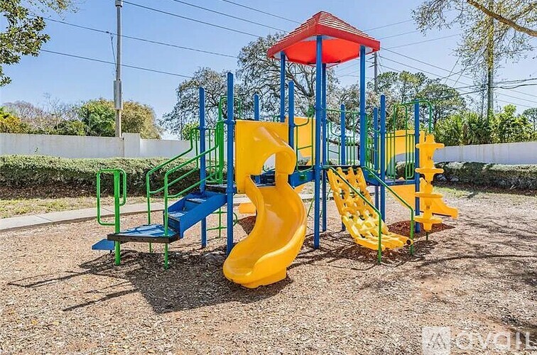 A playground with a yellow slide and a red roof.