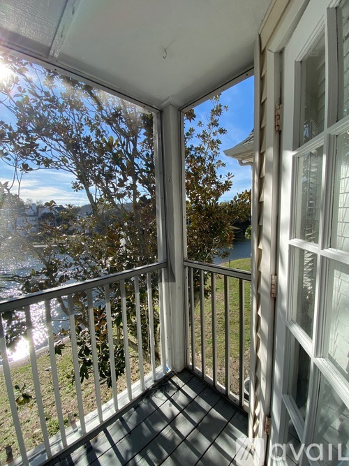 A balcony with a view of a body of water and trees.