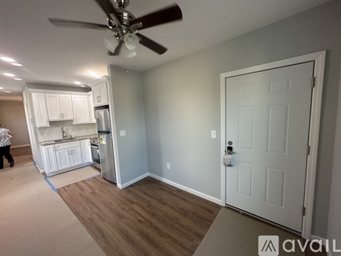 A kitchen with white cabinets and a refrigerator is shown.