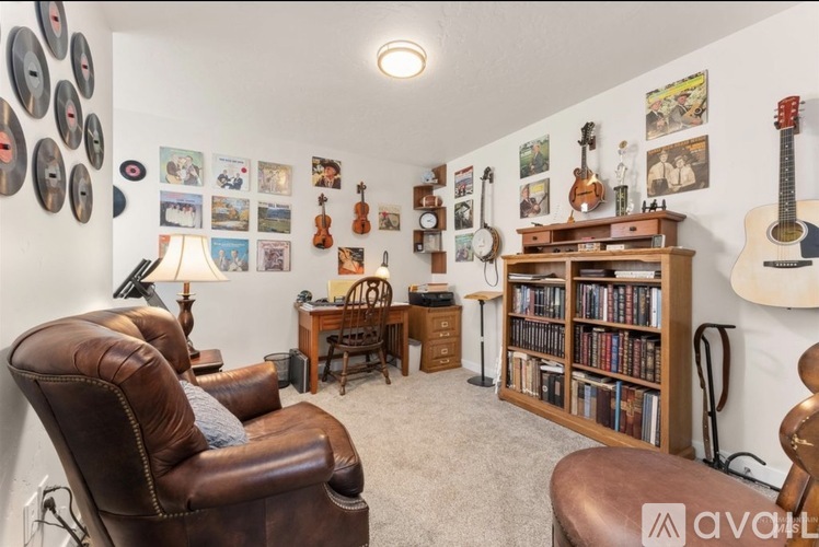 A living room with a brown leather chair and a bookshelf filled with books.