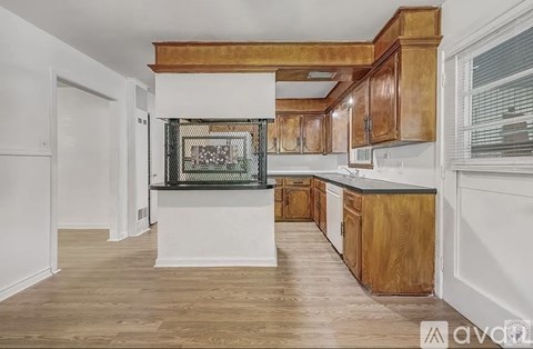 A kitchen with wooden cabinets and a black and white fridge.
