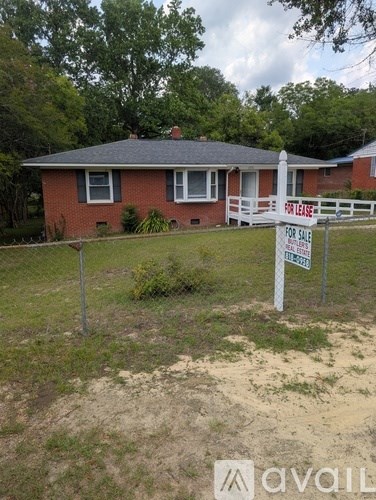 A red brick house with a sign that says "For Lease".