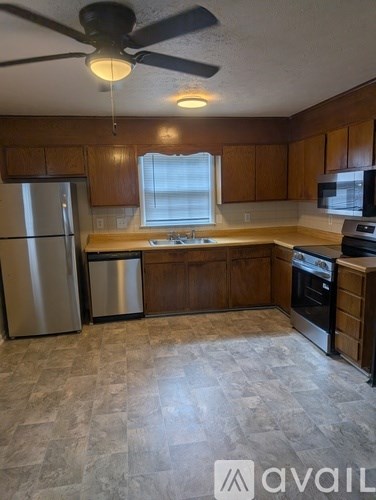 A kitchen with wooden cabinets and a tile floor.