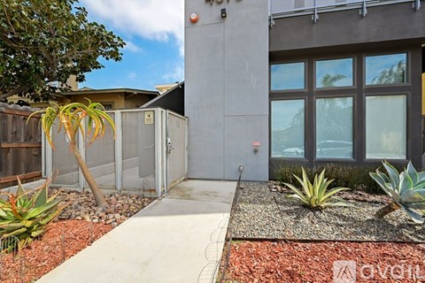 A modern house with a grey exterior and a glass door.