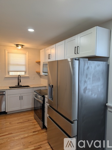 A kitchen with a refrigerator, oven, and sink.