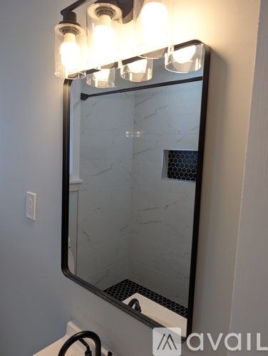 A bathroom mirror with lights on it.