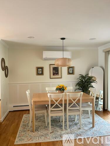 A dining room with a wooden table and chairs.