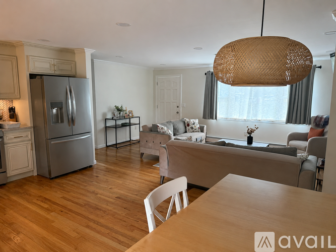 A modern kitchen with wooden floors and a large island with a dining table and chairs.