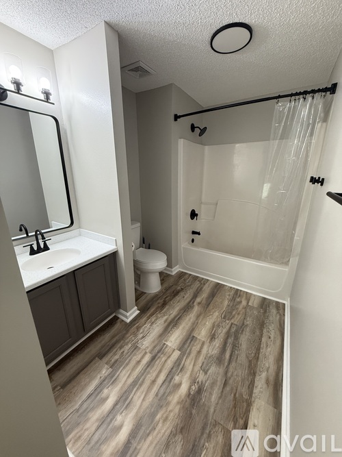 A bathroom with a toilet, sink, and shower.