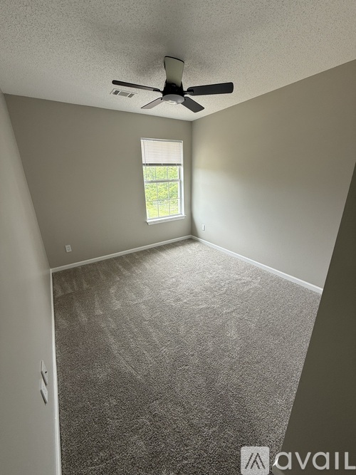 A room with a ceiling fan and a window.