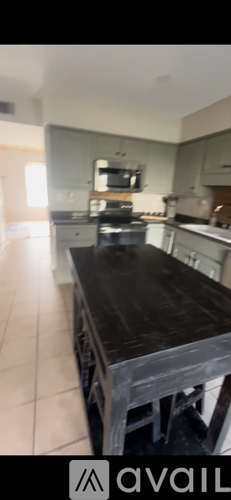 A kitchen with a wooden table and a microwave above it.