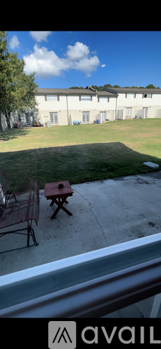 A building with a lawn and a picnic table in front.