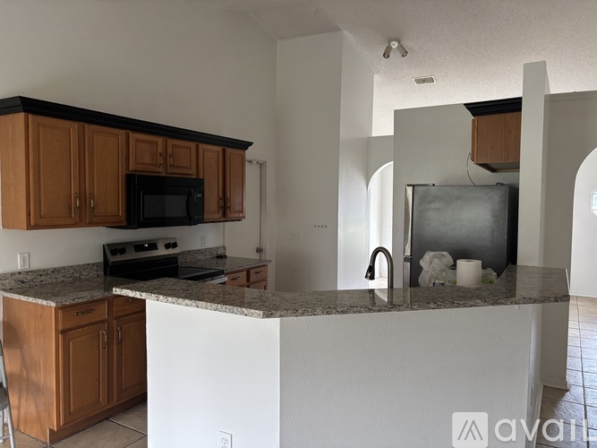 A kitchen with brown cabinets and a granite countertop.