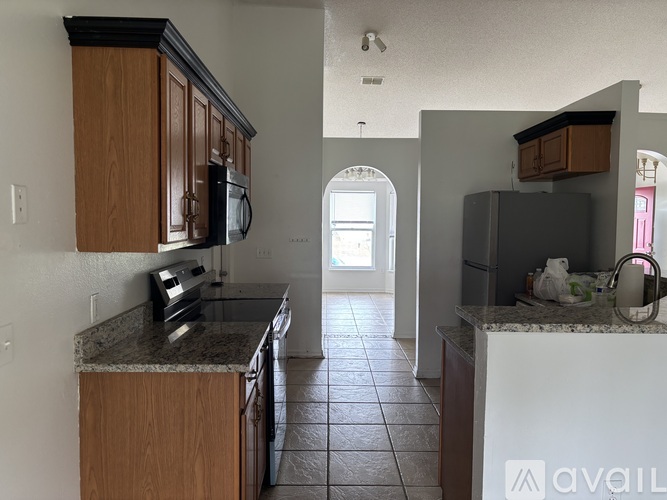 A kitchen with a black microwave above the counter.