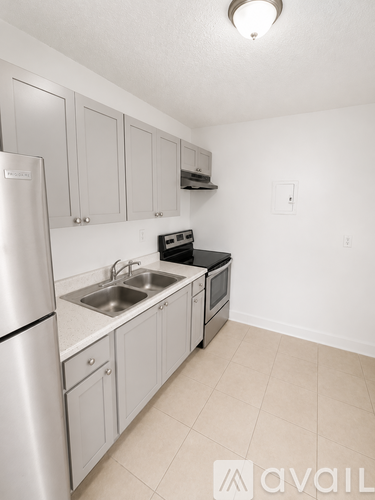 A kitchen with a refrigerator, sink, and stove.