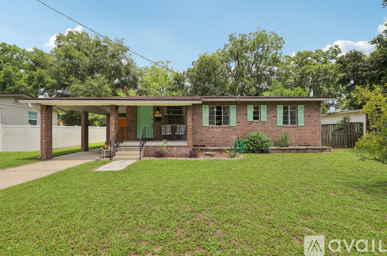 A house with a green lawn and trees in the background.