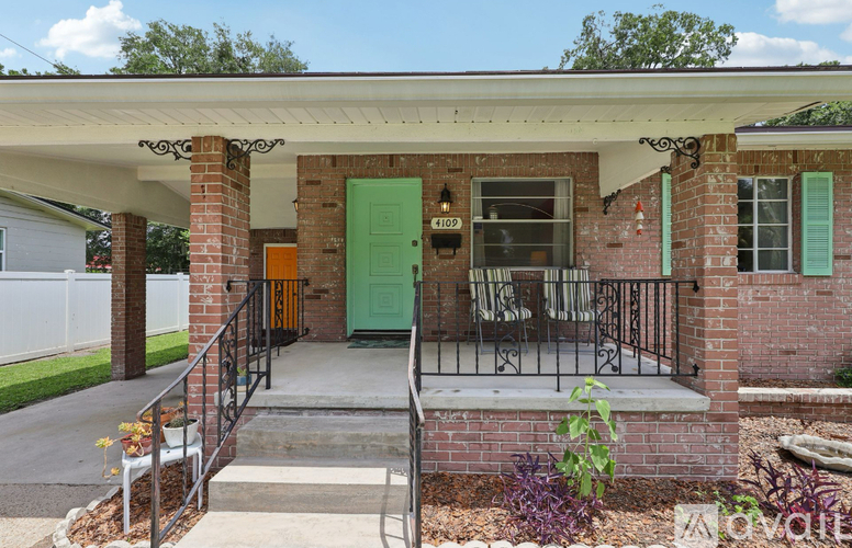 A house with a green door and a porch with a metal railing.