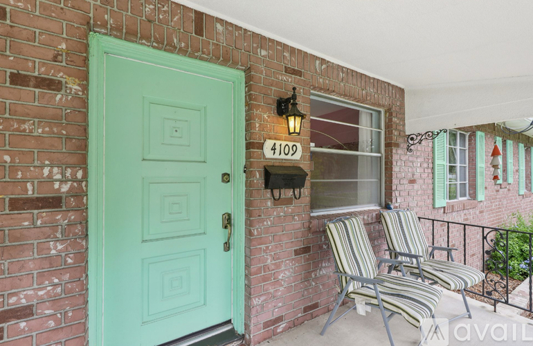 A green door is on the left side of a brick wall.