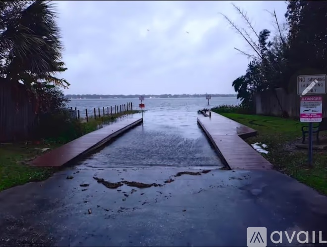 A flooded walkway with a sign that says "NO DRIVING" in the background.