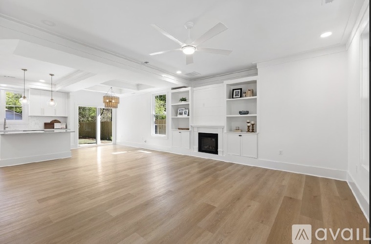 A spacious living room with a fireplace and built-in shelves.