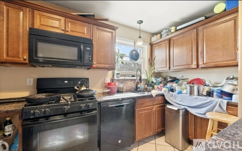 A kitchen with wooden cabinets and a black stove top oven.