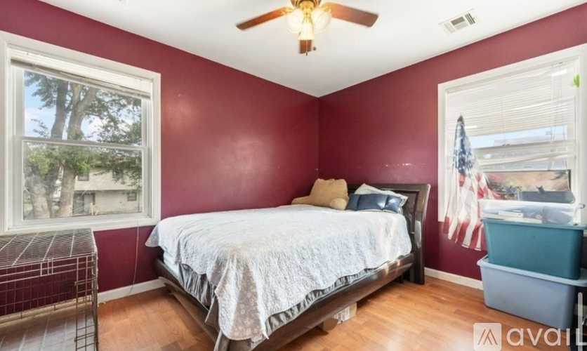 A bedroom with a bed, a window, and a ceiling fan.