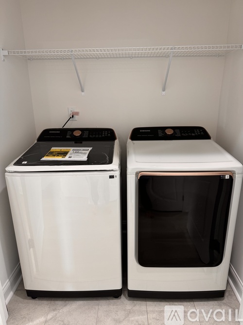 Two white front loading washing machines in a laundry room.
