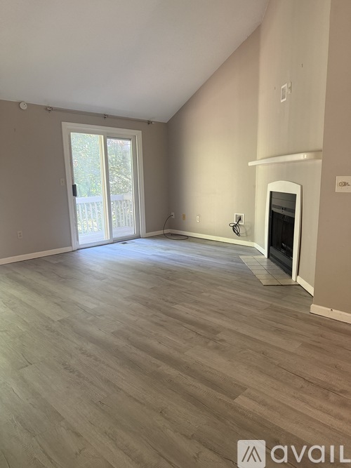 A room with a fireplace and a sliding glass door leading outside.