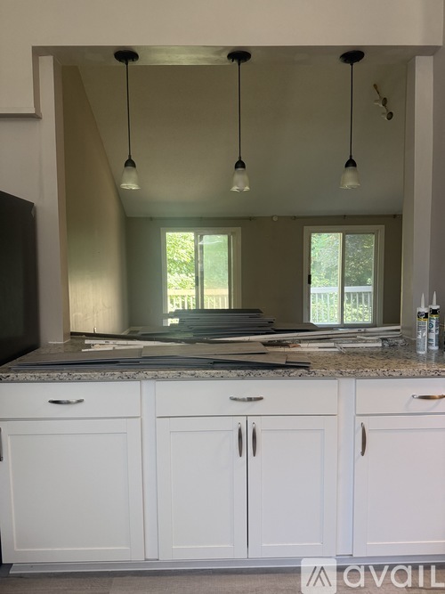 A kitchen with white cabinets and a granite countertop.