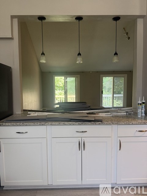 A kitchen with white cabinets and a granite countertop.