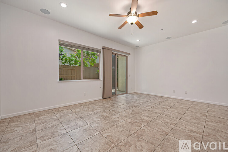 A spacious room with a ceiling fan and tiled flooring.