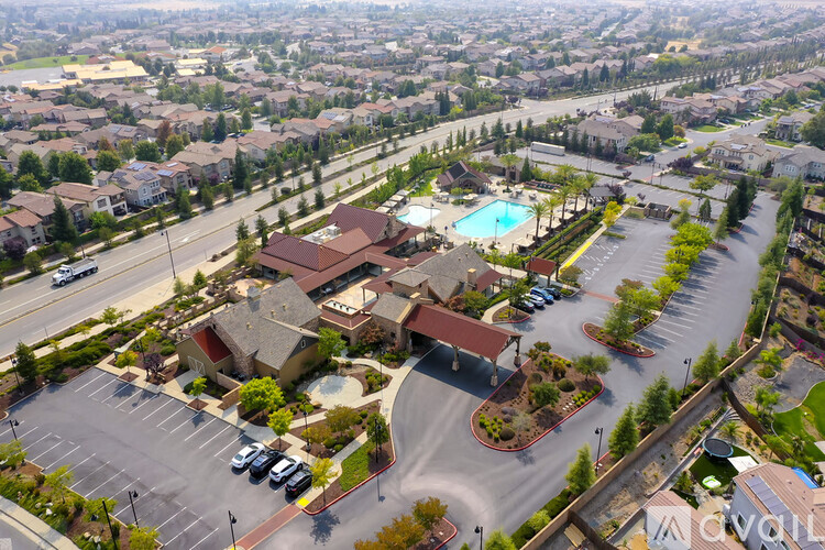 A bird's eye view of a residential area with a swimming pool and a parking lot.