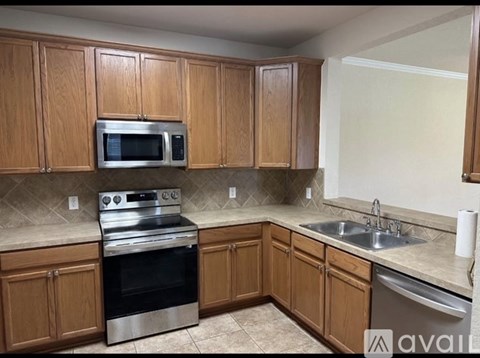 A kitchen with wooden cabinets and stainless steel appliances.