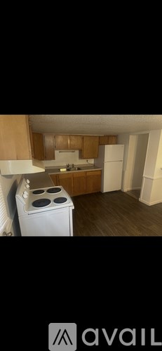 A kitchen with a white stove and wooden cabinets.