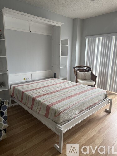 A bedroom with a bed, chair, and shelves.