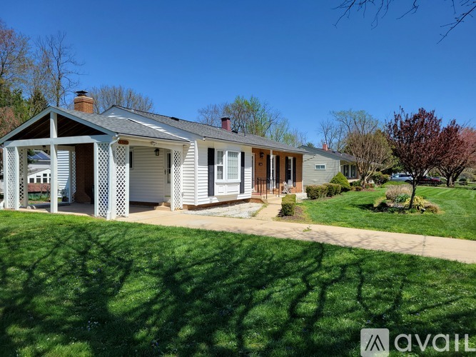 A house with a white porch and a brown roof is for sale.