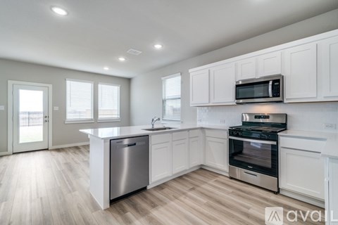 A kitchen with white cabinets and stainless steel appliances.