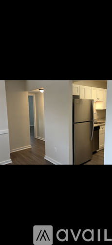A kitchen with a refrigerator and a door in the background.