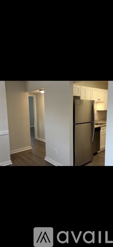 A kitchen with a refrigerator and a door in the background.
