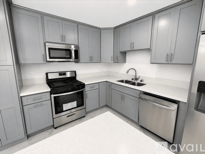 A modern kitchen with stainless steel appliances and grey cabinets.