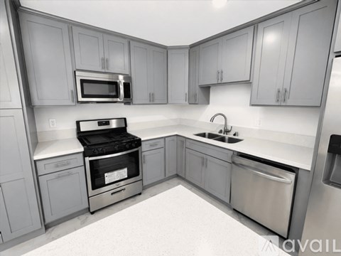 A modern kitchen with stainless steel appliances and grey cabinets.