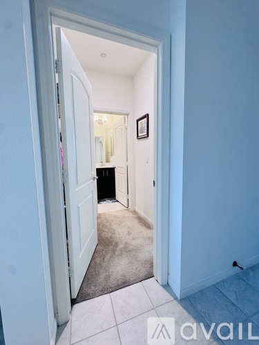A hallway with a carpeted floor and a white door.